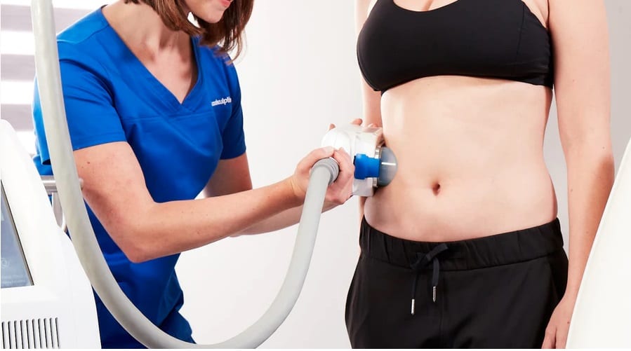 women applying coolsculpting device to female patient for fat removal