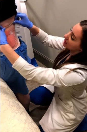 Rejuva Center nurse preforming coolsculpting treatment on male patient's back