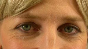 Close-up of a woman's face focusing on her eyes, showing her green eyes, light complexion, and blonde hair with visible emotions.