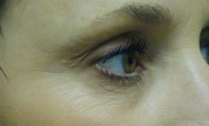 Close-up of a person's eye, featuring detailed view of eyelashes, iris, and skin texture, with a focus on natural, subtle tones.