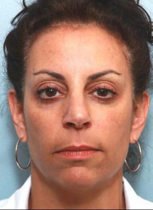 Headshot of a woman with medium skin tone, dark pulled-back hair, wearing hoop earrings, and a white shirt, looking directly at the camera with a neutral expression.