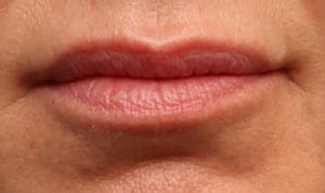 Close-up of a person's closed lips showing detailed texture and natural color without any cosmetics.