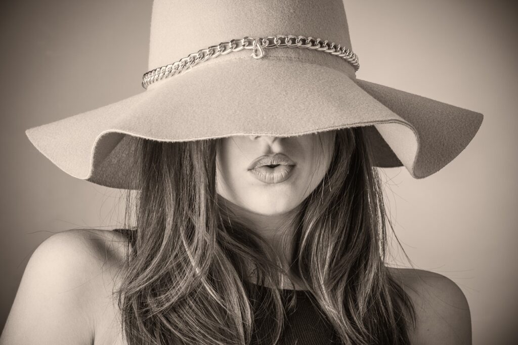 Woman wearing a hat that covers the top half of her face and shows her full lips after botox lip flip