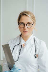 Female Botox® doctor in a white lab coat holding a clipboard 