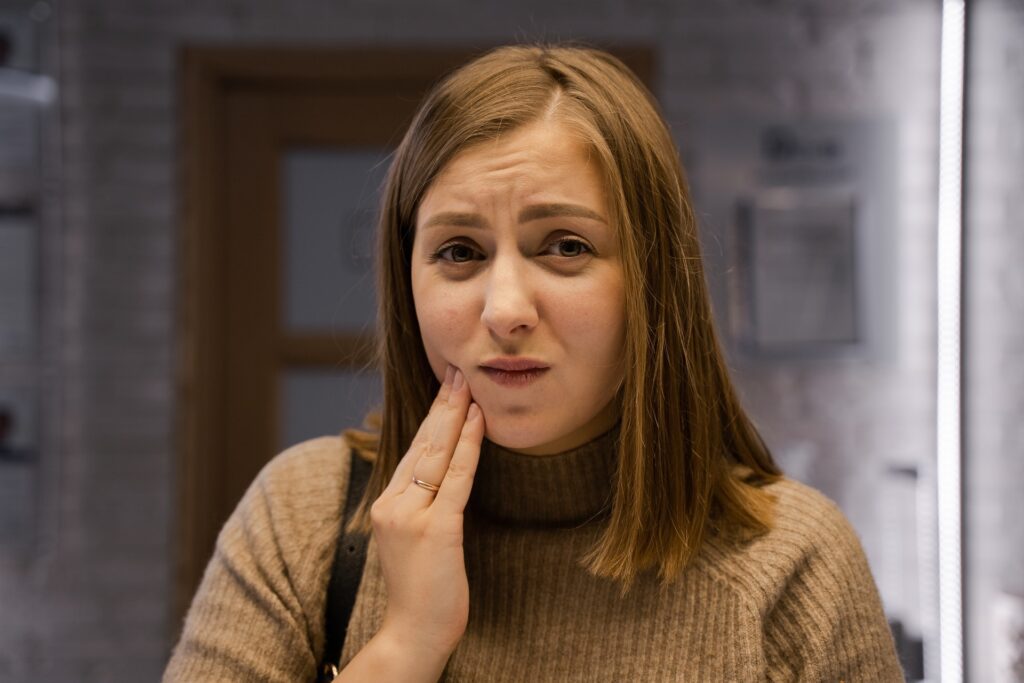 Woman with TMJ massaging her lower jaw