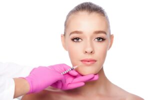 medical professional wearing pink latex gloves injecting lip fillers for a Russian lip augmentation