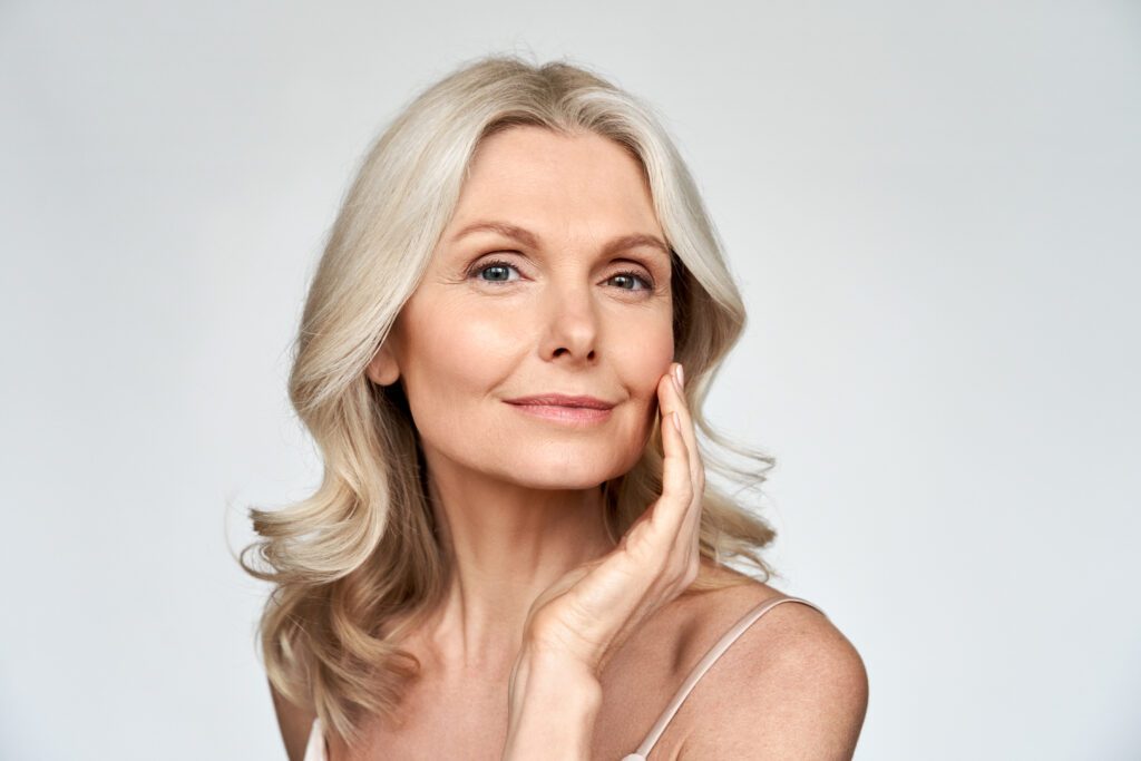 middle aged woman touches youthful skin